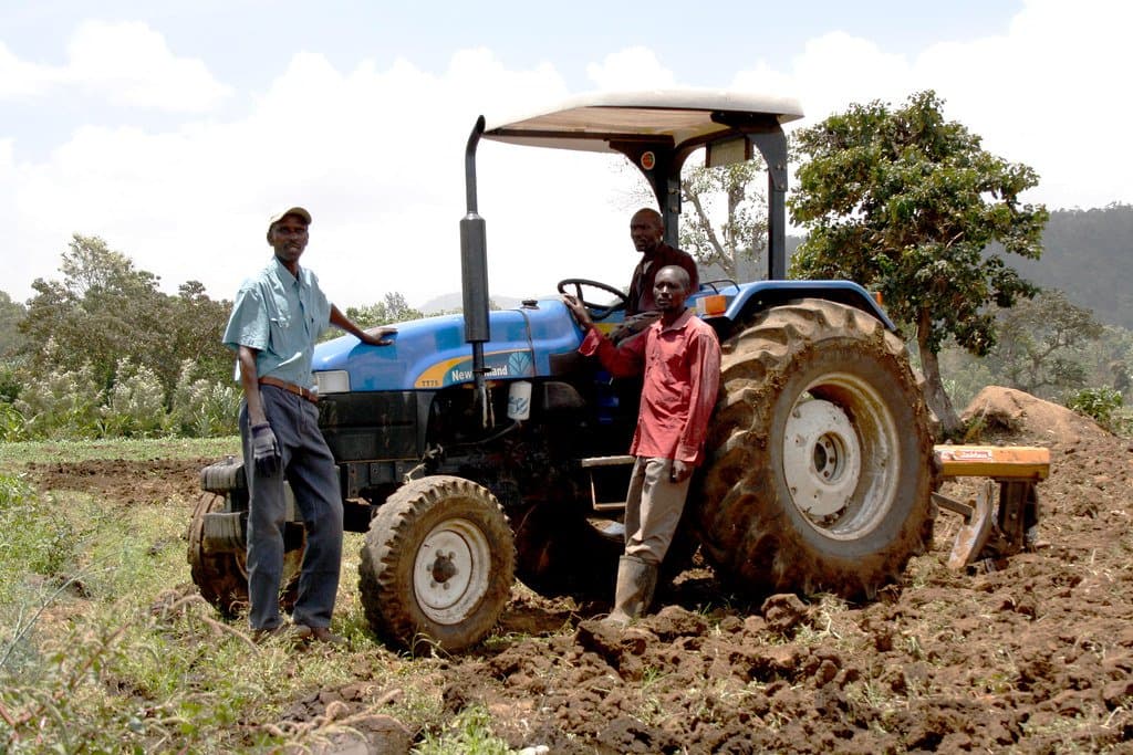 Agriculteurs posant avec leur nouveau tracteur équipé d'une charrue